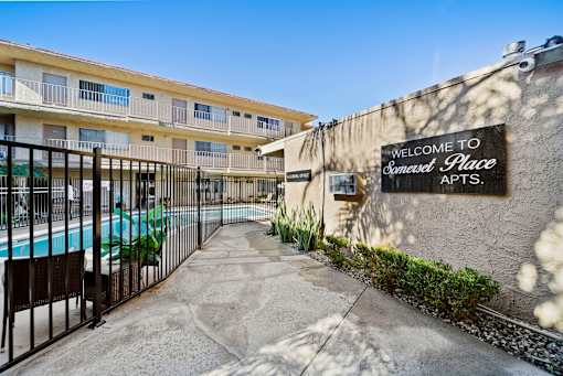 A sign that says "Welcome to Somerset Place Apts." is on a wall.