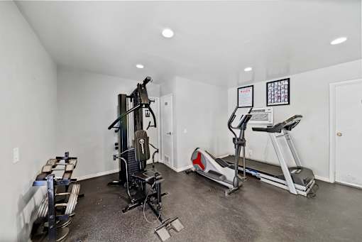 A home gym with a treadmill, elliptical trainer, and a weight machine.