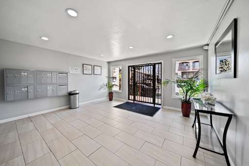 A hallway with a black railing and a mirror on the wall.