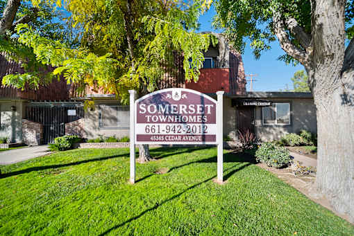 A sign for Somerset Townhomes stands in a grassy area.