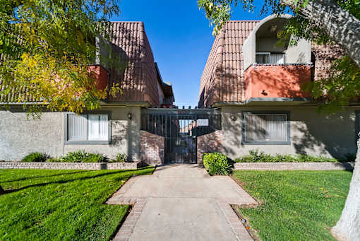 A building with a gate in the middle of a pathway.