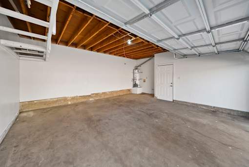 A spacious room with a concrete floor and a white door.