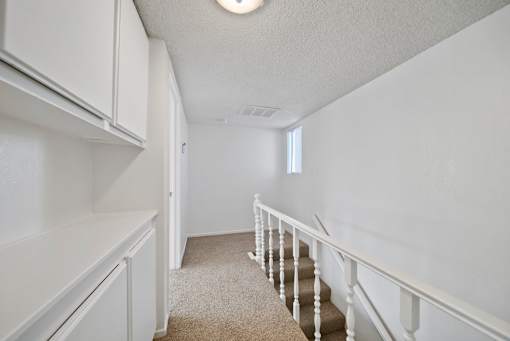 A white room with a staircase and a window.