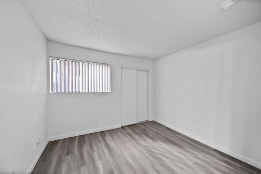A room with a window and wooden flooring.