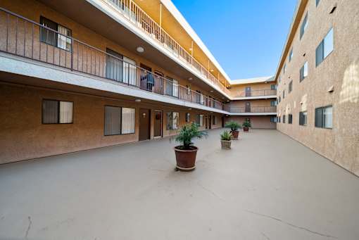 A courtyard with potted plants and balconies.