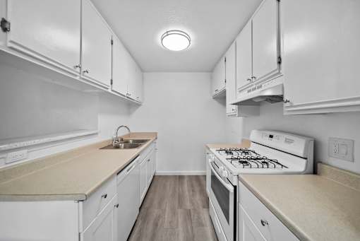 A kitchen with white cabinets and a beige countertop.