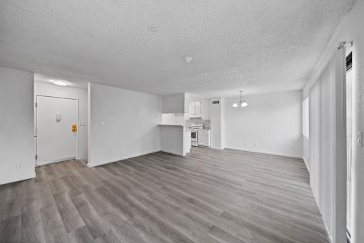 A spacious room with a grey floor and white walls.