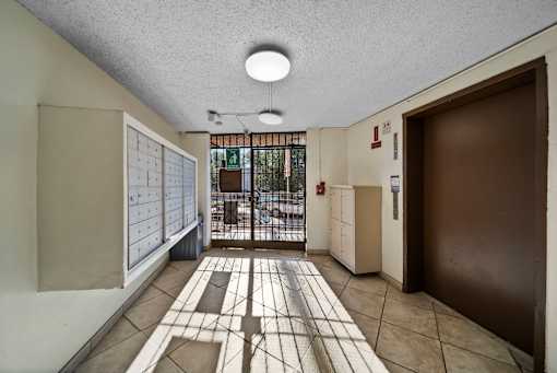 A hallway with a tiled floor and a door on the right.