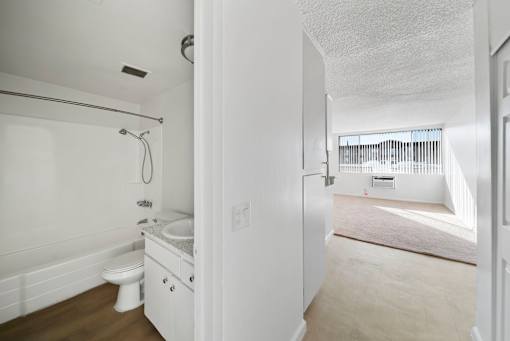 A white bathroom with a toilet, sink, and bathtub.