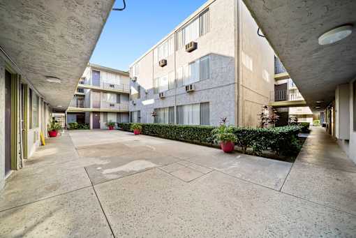 A courtyard with a concrete floor and apartment buildings in the background.