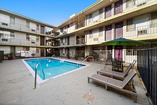 A pool in a courtyard surrounded by apartment buildings.