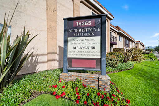 A sign for Southwest Pointe Apartments is displayed in front of a building.