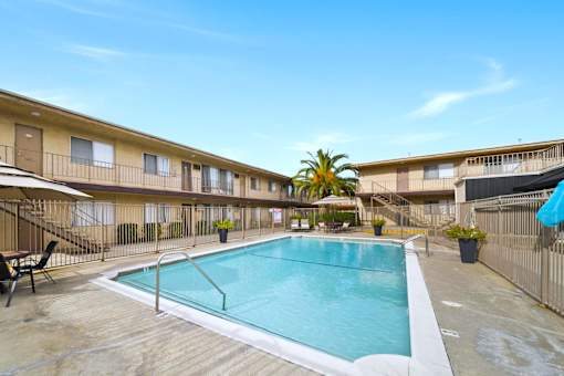 A pool in a courtyard surrounded by apartment buildings.