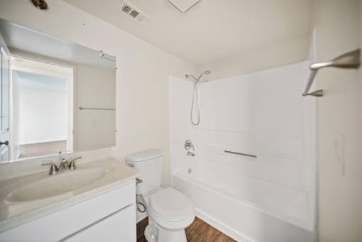 A white bathroom with a toilet, sink, and bathtub.