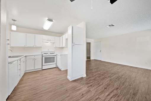 A kitchen with white cabinets and a stove top oven.