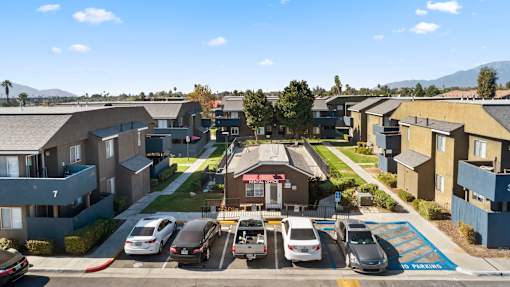 A sunny day in a residential area with cars parked in a row.