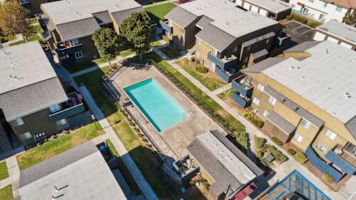 A swimming pool is surrounded by houses.