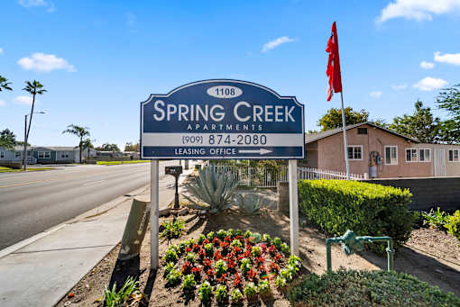 Spring Creek Apartments sign with a red flag on top.