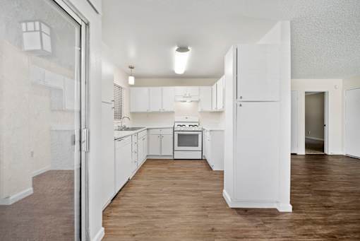 A kitchen with white cabinets and a white oven.