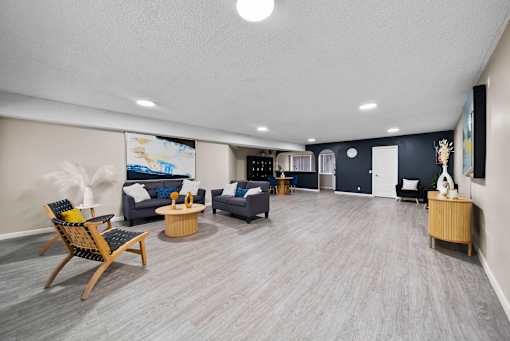 A spacious living room with a grey carpet and wooden flooring.