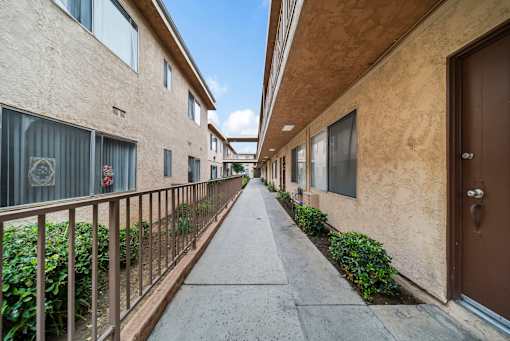 A long, narrow walkway separates apartment buildings.