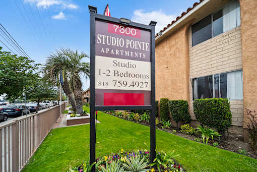 A sign for Studio Pointe Apartments with a phone number is displayed.