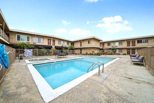 A pool in a courtyard surrounded by apartment buildings.