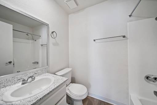 A white bathroom with a sink, toilet, and bathtub.