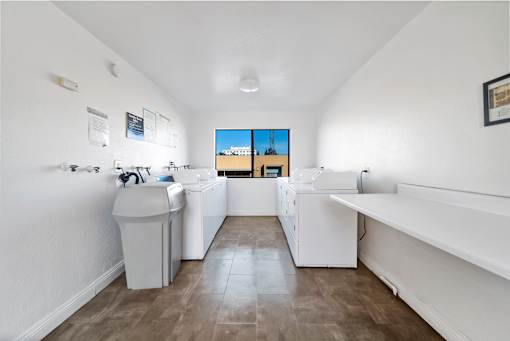 A laundry room with a washer and dryer, a sink, and a window.