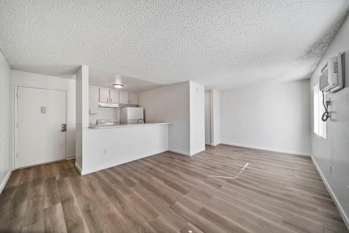 A room with wooden flooring and white walls.