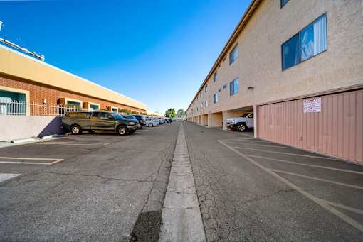 A parking lot with a yellow car and a white car.