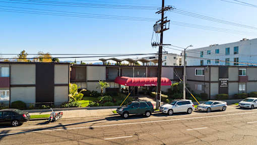 A parking lot with cars and a building in the background.