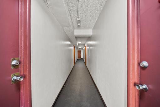 A long hallway with red doors on both sides.