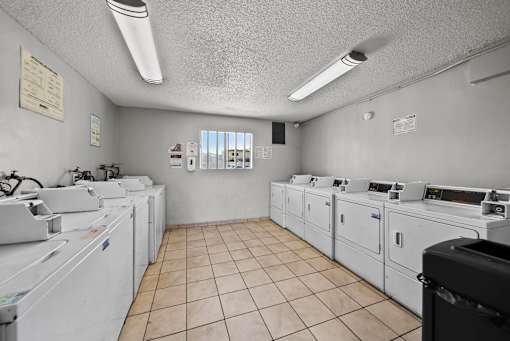 A laundromat with washers and dryers lined up.