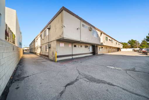 A parking lot in front of a building with a cracked ground.