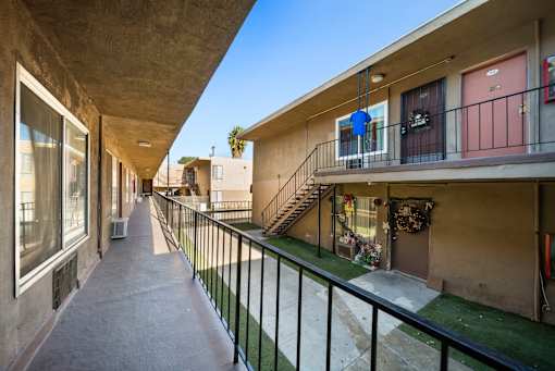A long concrete balcony with a black railing.