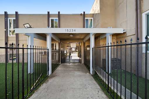 A long concrete walkway leads to a building with the number 15234 on it.