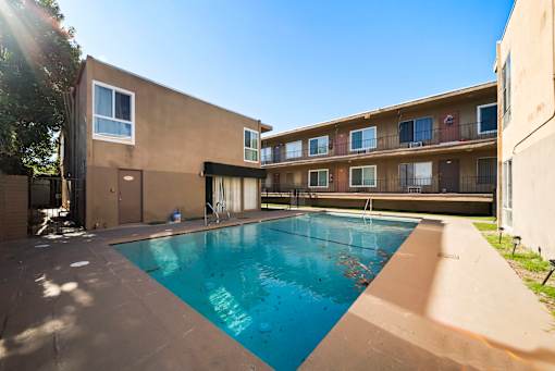 A swimming pool in a courtyard surrounded by buildings.
