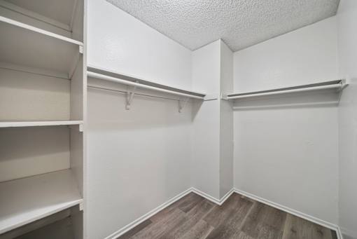 Empty white shelves in a room with wood flooring.