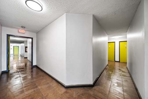 A long hallway with yellow doors at the end.