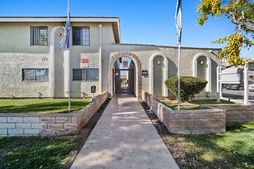 A building with a flag on top and a gate in front.