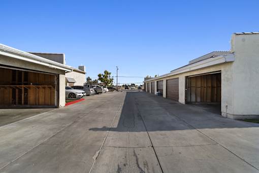 A long, empty parking lot with cars parked on the side.