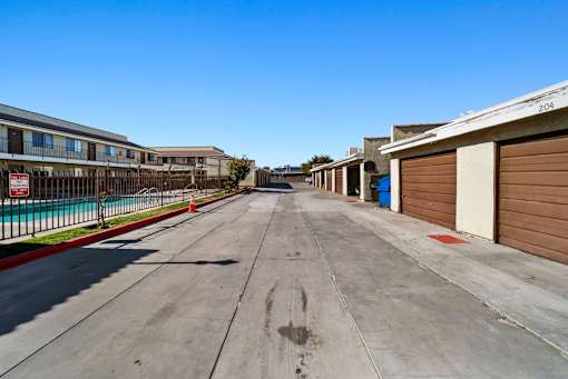 A long, empty street with apartment buildings on either side.