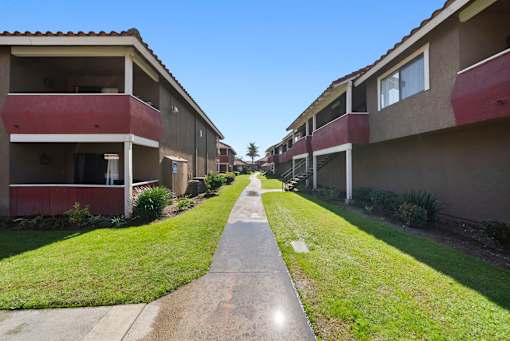 A long, narrow pathway separates two rows of apartment buildings.