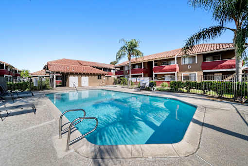 A swimming pool in a sunny outdoor setting.