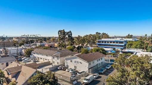 A clear blue sky over a residential area with houses and parked cars.