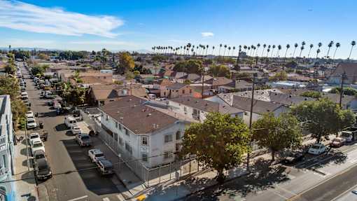 A street view of a residential area with houses and parked cars.