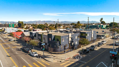 A street view of a residential area with houses and cars.