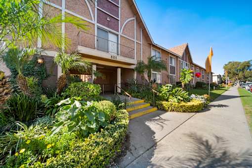 A building with the number 8101 on it is surrounded by green plants.