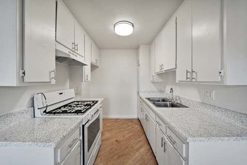A kitchen with white cabinets and granite countertops.